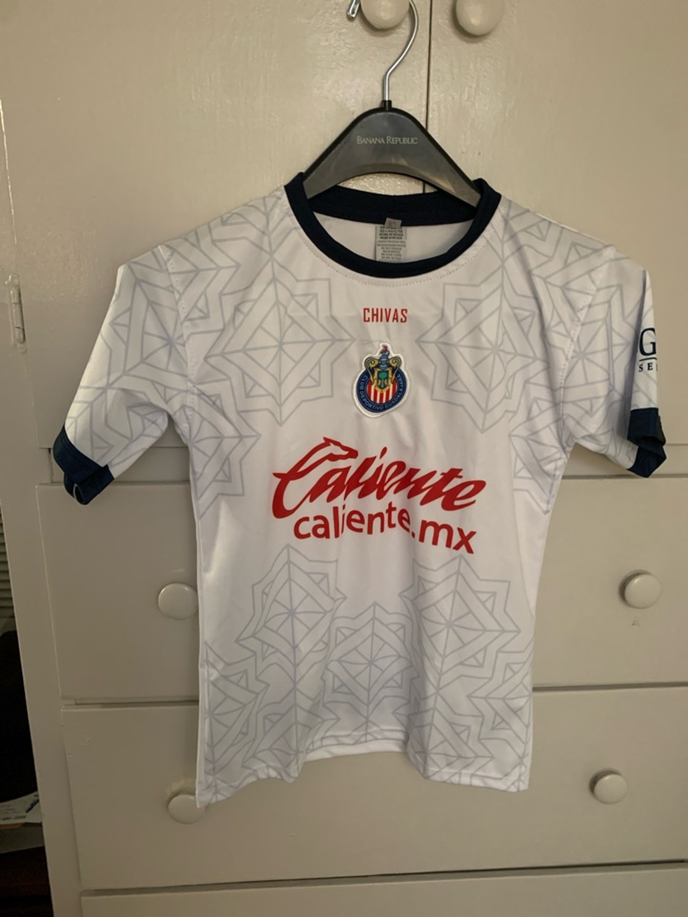 Civas Kids White Jersey with Navy Trim and Red Sponsor Logo